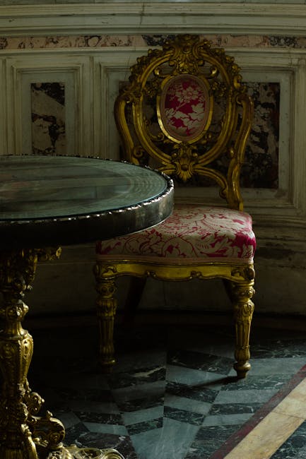 A close-up of an antique-style sofa with a green velvet upholstery and an ornate wooden frame with intricate carvings, situated against a plain, light-colored wall. The sofa appears clean and well-maintained, showcasing smooth fabric without visible dust or stains. The lighting is soft, illuminating the detailed woodwork and the rich texture of the velvet. This image exemplifies surface cleaning and maintenance suitable for period homes, as offered by Fulham Carpet Cleaning. The setting suggests a cozy, traditional interior space focused on aesthetic preservation through professional cleaning services.